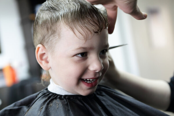 Laughing kid at barbershop