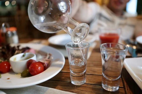 Person fills glasses of vodka — Stock Photo, Image