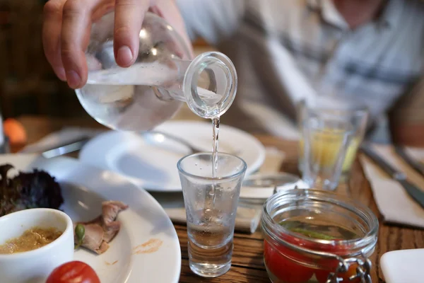 Bartender pouring vodka from the decanter — Stock Photo, Image