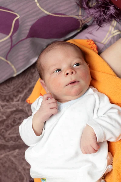 Newborn on an orange blanket — Stock Photo, Image