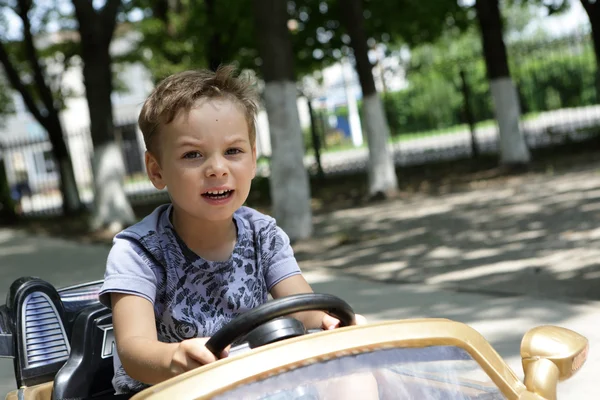 Ragazzo che guida una macchina giocattolo — Foto Stock