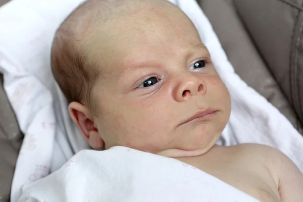 Серьезный новорожденный ребенок — стоковое фото