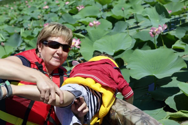 Grandmother and grandson looking at Indian lotus — Stock Photo, Image