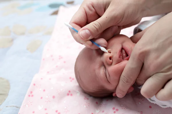 Moeder schoonmaak baby jongen neus — Stockfoto