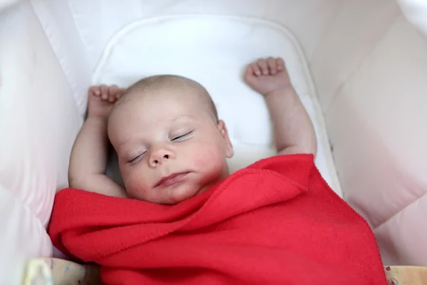 Baby sleeping under red blanket — ストック写真