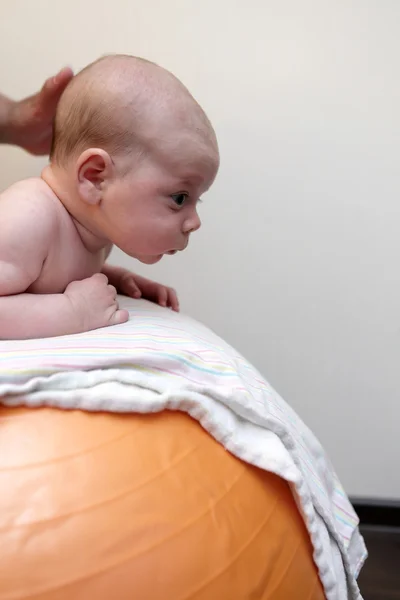 Babyjongen uitoefenen op een gymnastiek bal — Stockfoto