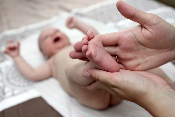 Moeder de pasgeboren jongen voet masseren — Stockfoto