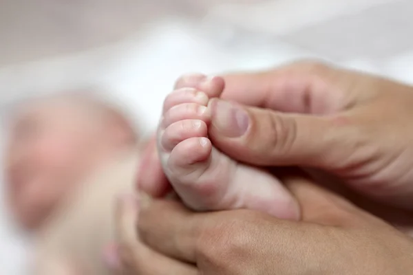 Moeder de baby voet masseren — Stockfoto