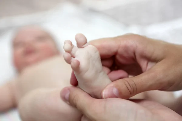 Moeder de pasgeboren voet masseren — Stockfoto
