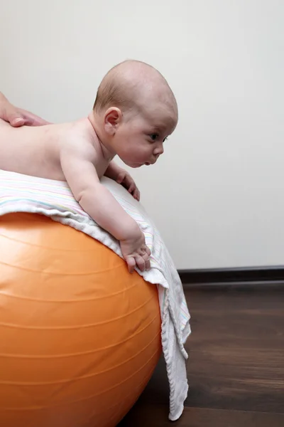 Newborn baby boy exercising on a gymnastic ball — Stock Photo, Image