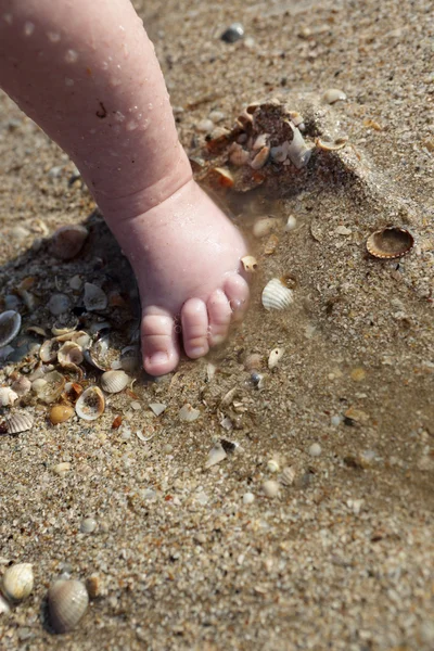 Nyfödd baby boy foten i sanden — Stockfoto