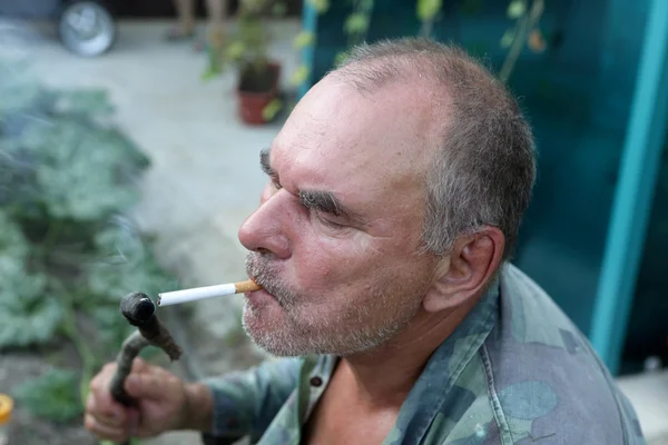 Homem acende um cigarro — Fotografia de Stock