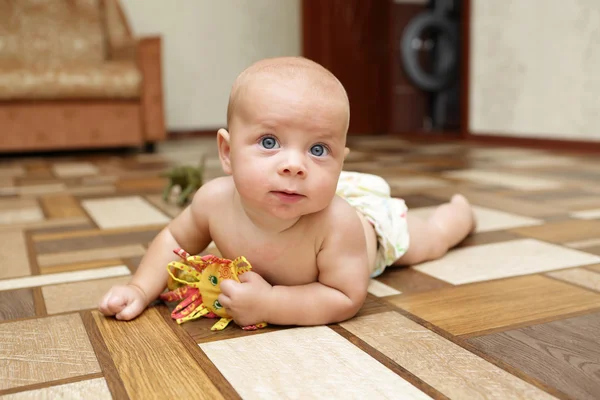 Baby spielt mit Spielzeug auf dem Boden — Stockfoto