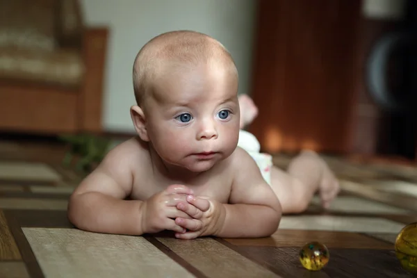 Pensive baby boy lying on the floor — Stock Photo, Image