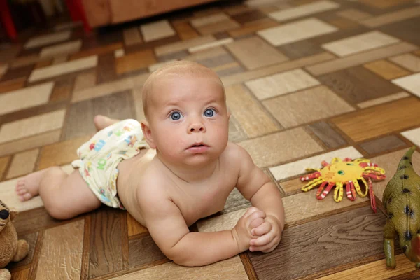 Menino sério rastejando no chão — Fotografia de Stock