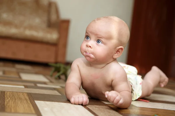 Bebê surpreso rastejando no chão — Fotografia de Stock