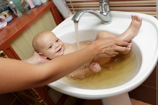 Madre bañando al bebé en el fregadero — Foto de Stock