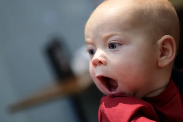 Ребёнок зевает в помещении — стоковое фото