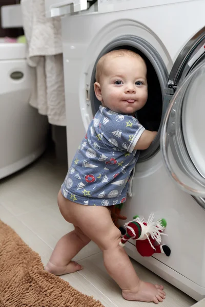 Улыбающийся ребенок со стиральной машиной — стоковое фото