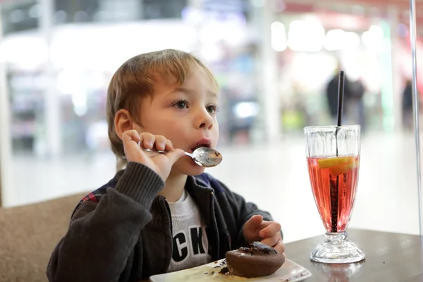 Menino comer bolo de chocolate — Fotografia de Stock