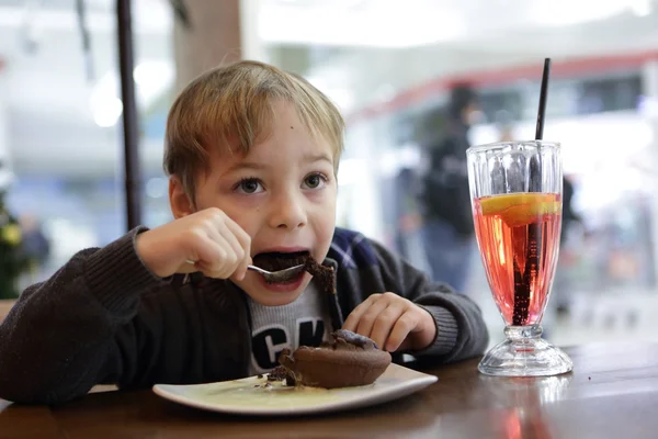 Ребенок ест шоколадный торт — стоковое фото