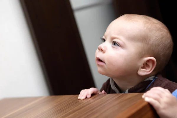 Curious baby boy and a chest of drawers — Stock Photo, Image