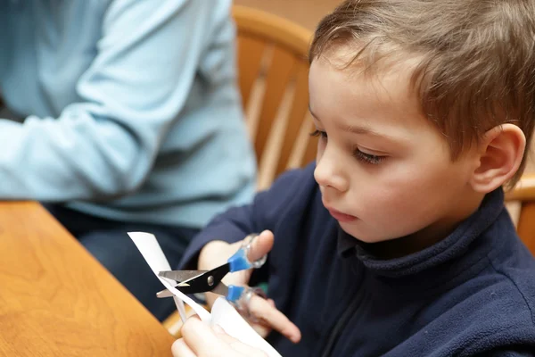 Kind maken papier sneeuwvlokken — Stockfoto