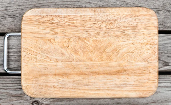Vista superior de tabla de cortar de madera en la mesa vieja — Foto de Stock