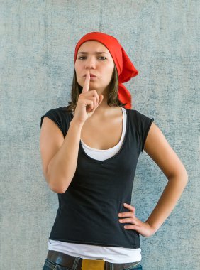 Genç güzel kadın işaret parmağı sil işareti olarak dudaklarını koydu