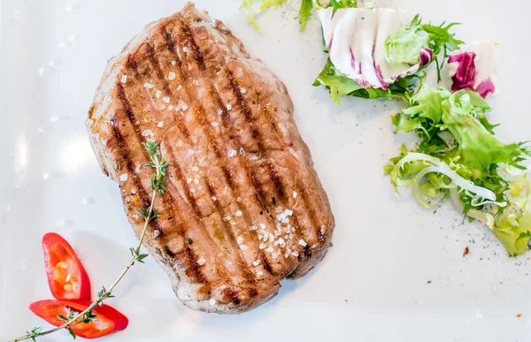 Bistecca alla griglia con insalata sul piatto — Foto Stock