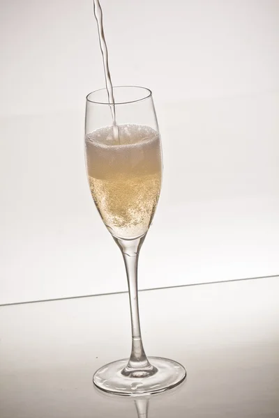 Champagne flowing in glass — Stock Photo, Image