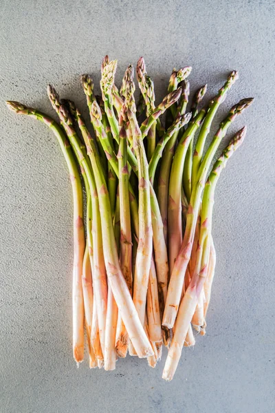 Fresh asparagus on gray — Stock Photo, Image