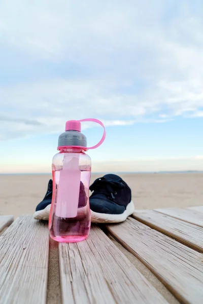 Vatten i flaska och sport skor — Stockfoto