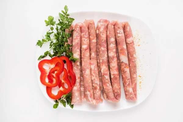 Raw sausages with vegetables — Stock Photo, Image