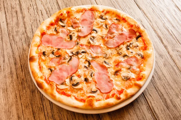 Pizza op houten ondergrond — Stockfoto