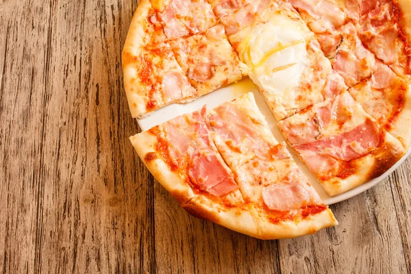 Pizza op houten ondergrond — Stockfoto