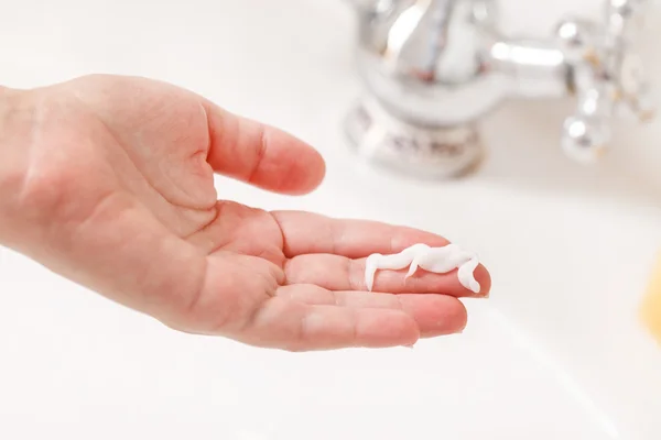 Mano femminile con crema — Foto Stock