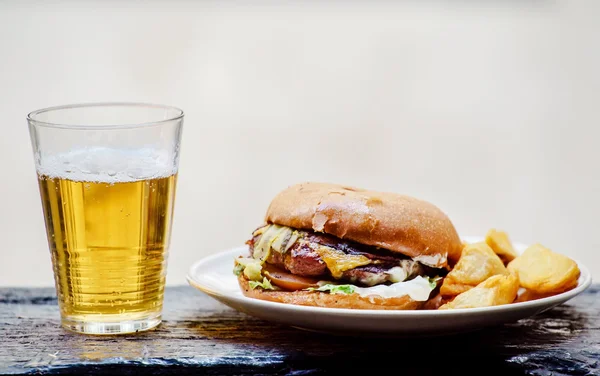 Hamburger s pivem na desce — Stock fotografie