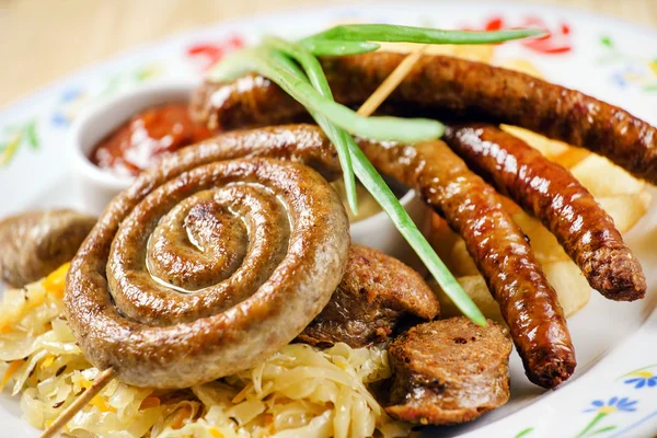 Sausages on sauerkraut on plate — Stock Photo, Image