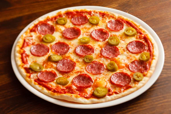 Välsmakande pizza på tallrik — Stockfoto