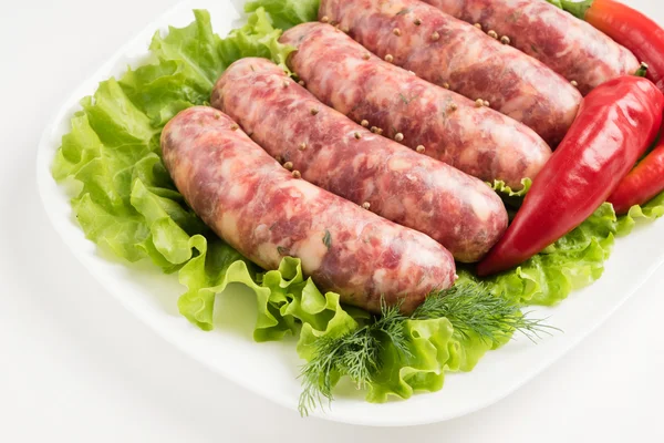 Raw sausages with vegetables — Stock Photo, Image