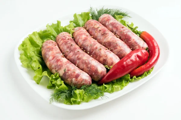 Raw sausages with vegetables — Stock Photo, Image