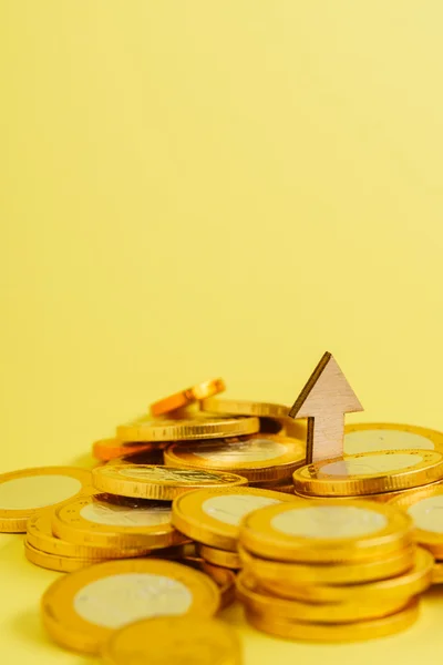 Monedas con flecha de madera —  Fotos de Stock