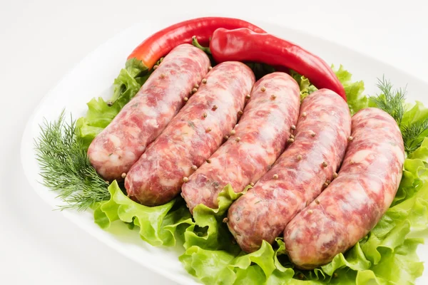 Raw sausages with vegetables — Stock Photo, Image
