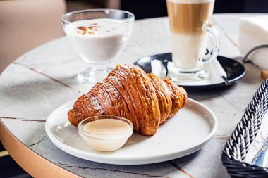 Kafede kruvasan ve kapuçino.