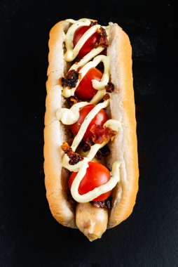 Siyah arka planda sosisli sandviç.