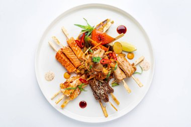 Beyaz tabakta et ve balık kebabı