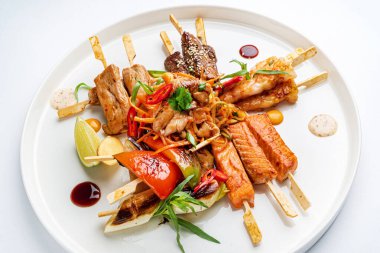 Beyaz tabakta et ve balık kebabı