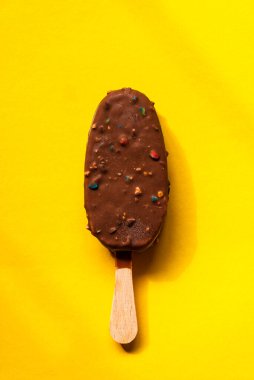 Sarı arka planda çikolatalı dondurma.