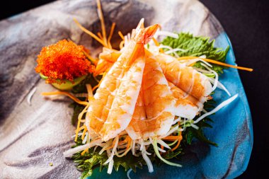 Siyah arkaplanda suşi var.